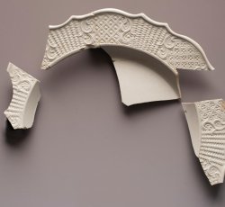 White salt glaze stoneware dot, diaper, and basket molded plate.