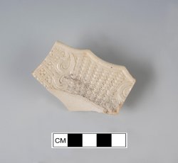 White salt glaze stoneware dot, diaper, and basket molded plate.