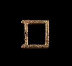 Small copper alloy single frame strap buckle.