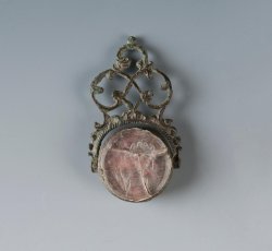Copper alloy watch fob swivel seal with classical figure molded in intaglio.
