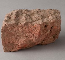 Handmade brick bat with finger impressions.