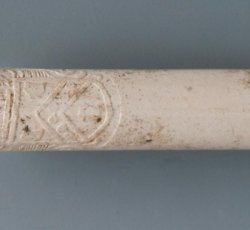 Tobacco pipe stem decorated with fox and grapes and crest.