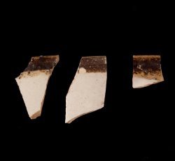 White slip-dipped stoneware mug rim.