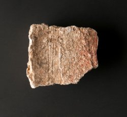 Plaster fragment with iron-oxide pigment.