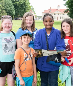 Students smiling in front of the mansion