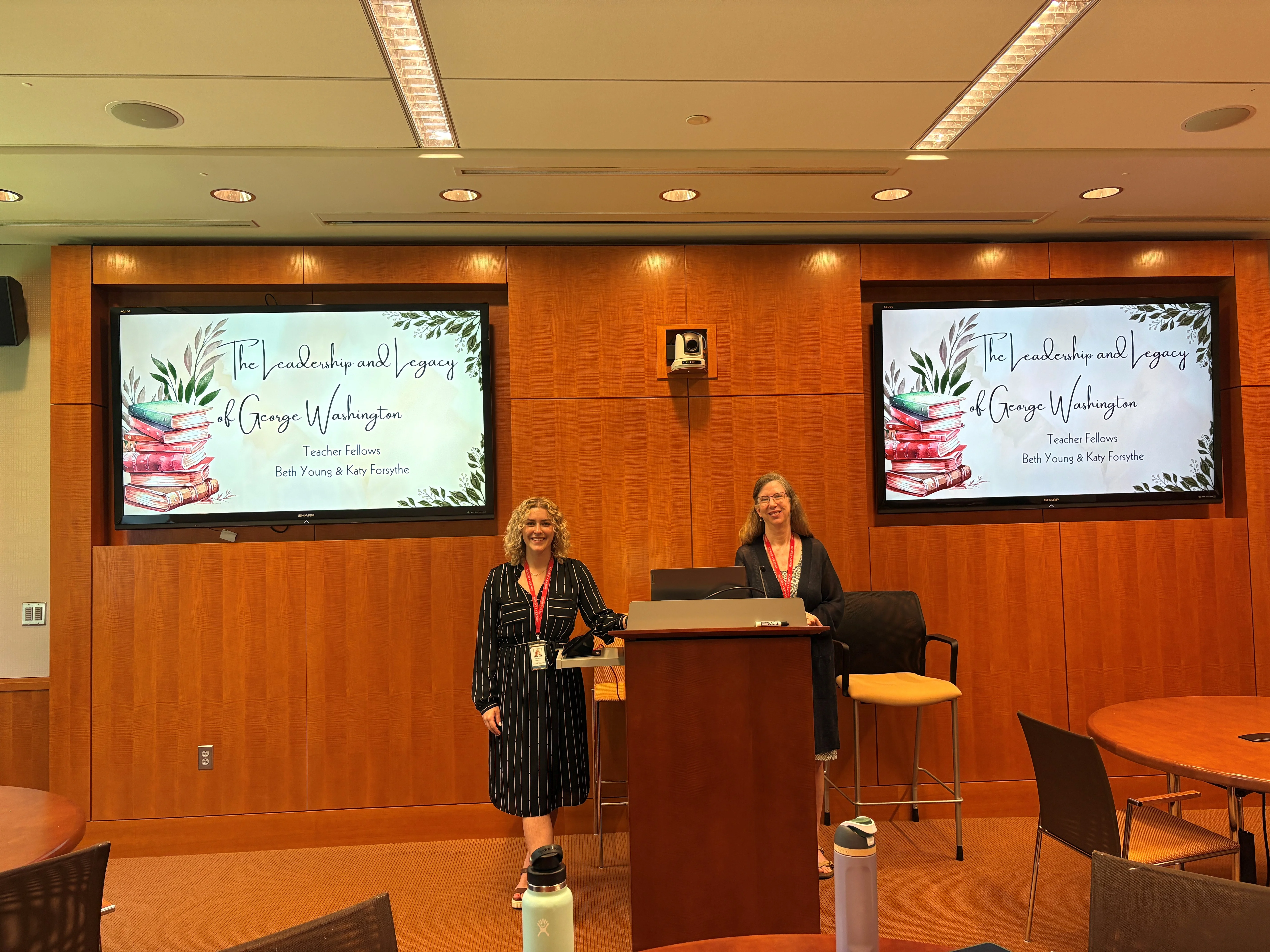 two people standing in front of a screen