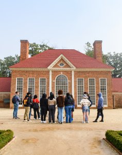 Students standing in front of green house