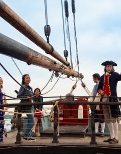 Students and colonial actor on a boat