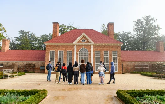 Students standing in front of green house