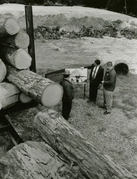 Examining a photograph of Washington's original barn next to lumber being used in the reconstruction.