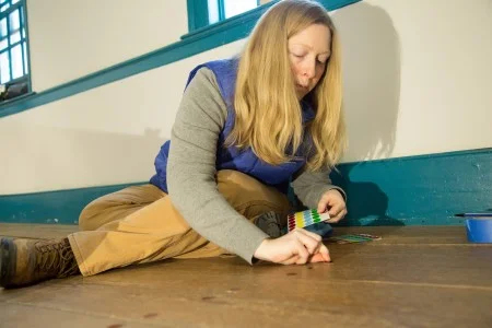 Architectural Research Manager Caroline Spurry marks the nails in the floor of the Blue Room. (MVLA)