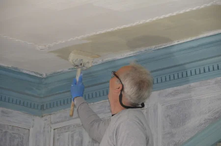 Whitewashing the front parlor's ceiling using period-based whitewash recipe.