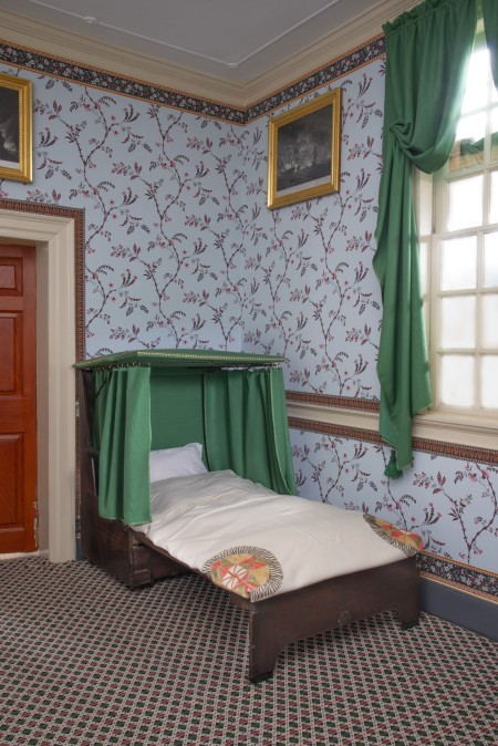 The settee bedstead open and set up as a bed, complete with Saxon green moreen curtains around the head.