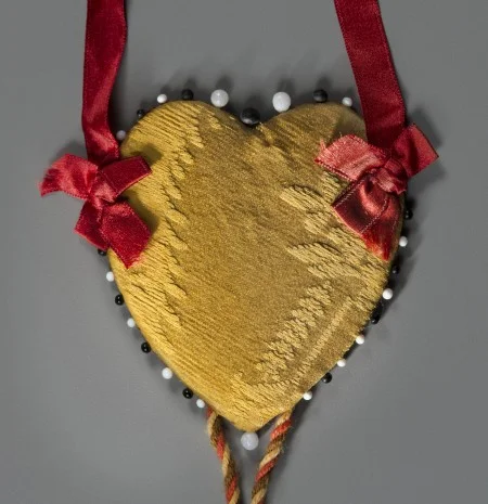 A fragment of the original silk and wool damask, made into a valentine in 1913.