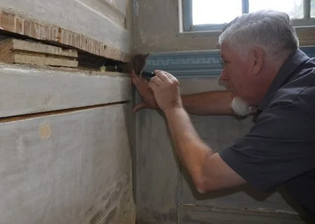 Director of Architecture Thomas Reinhart investigates an interior wall of the Mansion. (MVLA)