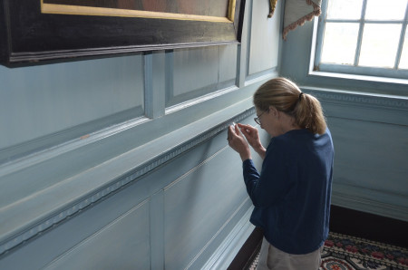 Susan Buck removing paint in the Front Parlor to examine, MVLA.