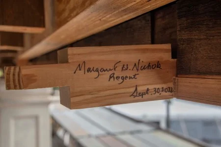 During 2022 work on the Mansion’s east front, MVLA Regent Margaret Nichols signed one of the small wooden pieces used in the entablature. (MVLA)