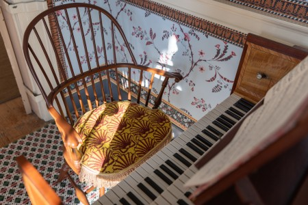 View of the Windsor chair with shell cushion before the harpsichord.