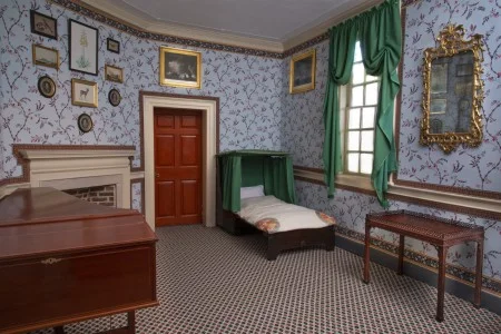 The settee bedstead open and set up as a bed, complete with Saxon green moreen curtains around the head.