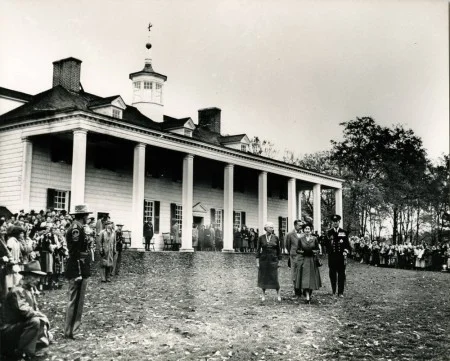 Princess Elizabeth and Prince Philip, on the east lawn at Mount Vernon, accompanied by Mrs. Hope Powel Regent of the Mount Vernon Ladies' Association and Resident Superintendent Charles C. Wall. Visitors and press gather on the perimeter. (Mount Vernon Ladies' Association)