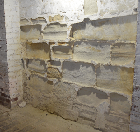 Over the years, fluctuations in humidity levels within the cellar have damaged the original sandstone walls. Evidence of that deterioration can be seen in the accumulation of sand at the base of the wall. (MVLA)