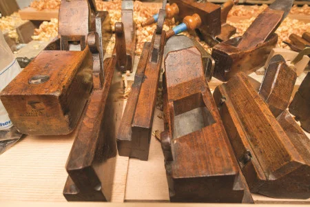 Planes shape wood by using strength to force the iron blade across the surface. From left: badger plane, two molding planes, and two dado planes. 